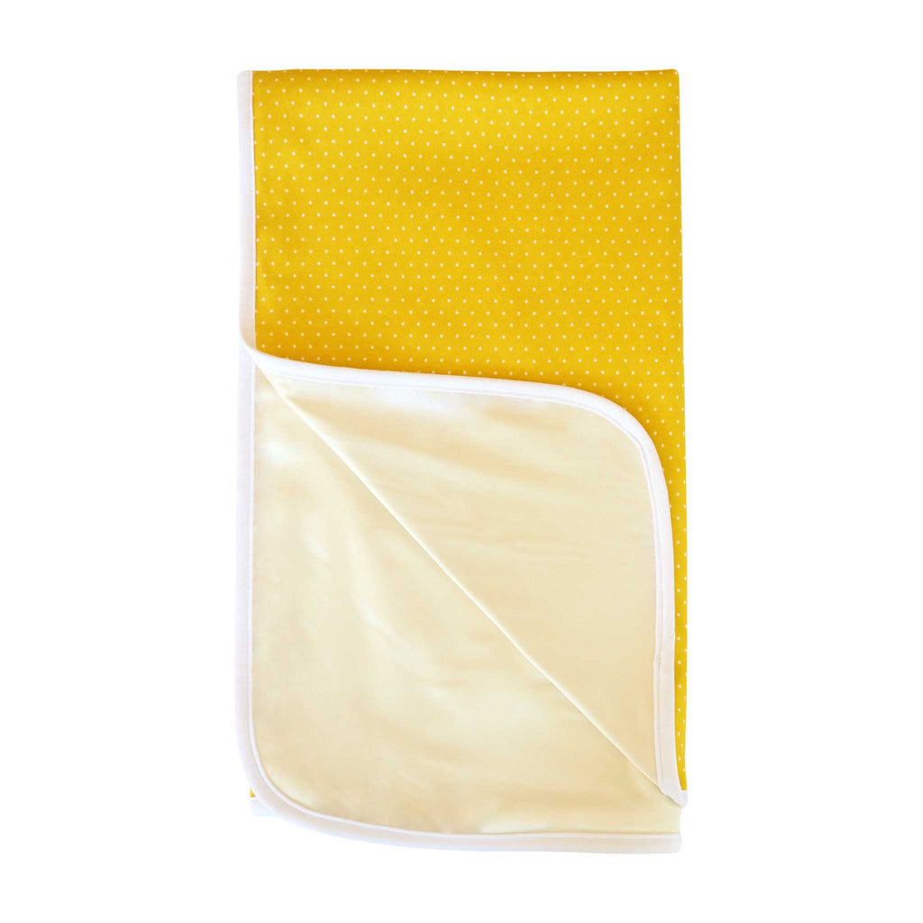 Alli.C, double-sided gender neutral yellow with white polka dots baby blanket. This 100% organic cotton unisex baby blanket has an off white silk charmeuse lining, and white binding.
